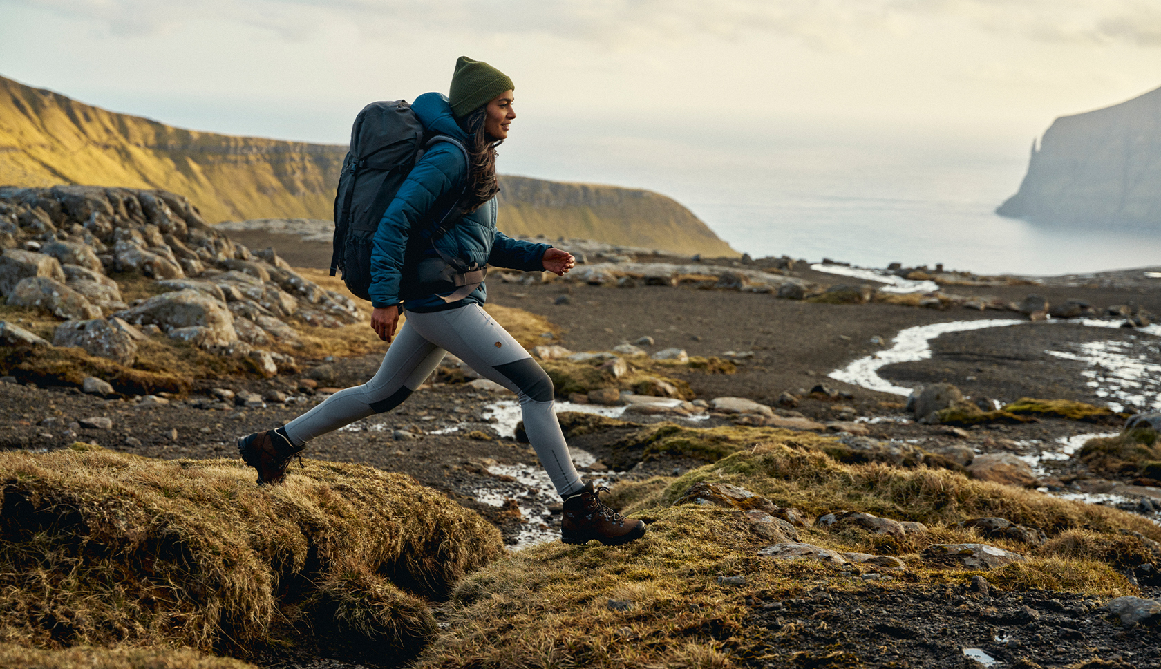 A woman wearing a Mountain Equipment jacket and helmet climbing