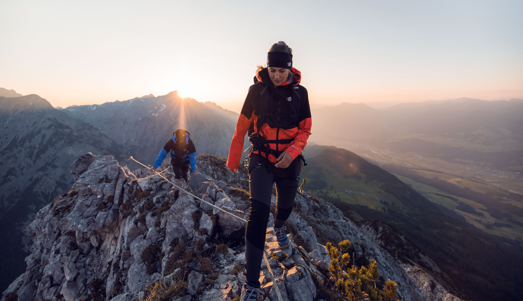 A woman wearing a Mountain Equipment jacket and helmet climbing