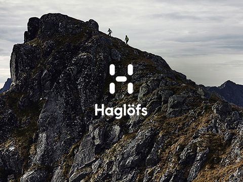 Two people walking up a mountain, wearing Haglofs gear.