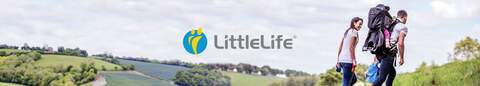 A man is carrying one child in a LittleLife carrier on his back while another child is holding his hand and a woman is holding dog's lead, walking through fields on a cloudy day, with the littlelife logo in the center.