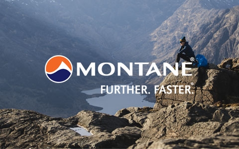 Woman sitting on a rock and looking over a rock valley, wearing Montane gear