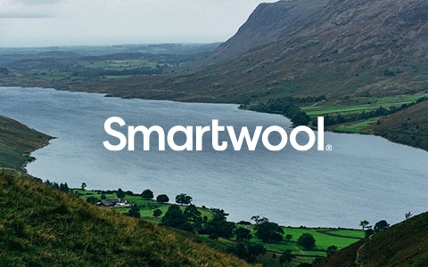 A lake surrounded by mountains with the Smartwoll brand logo in the middle
