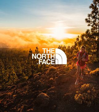 Woman running through hillside wearing The North Face gear