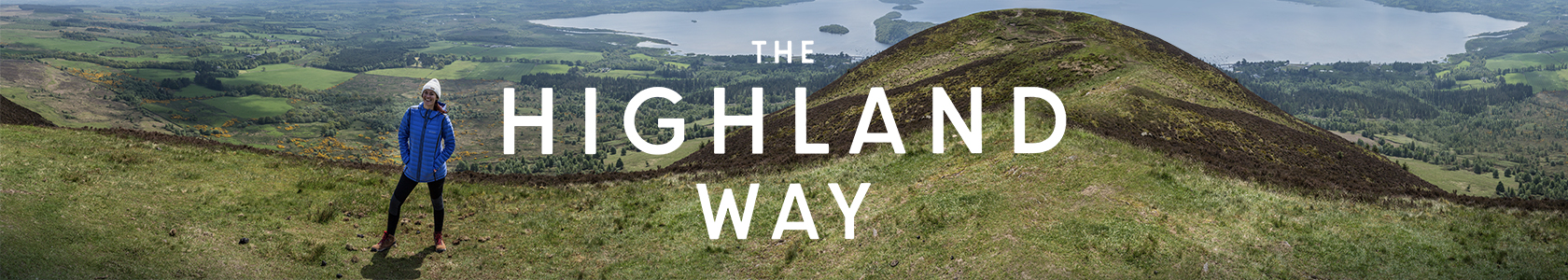 The Highland way - a woman is standing on a hill, wearing Columbia gear.