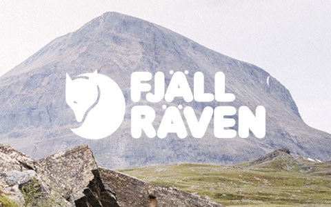 A couple walking in mountains, wearing Fjallraven gear.