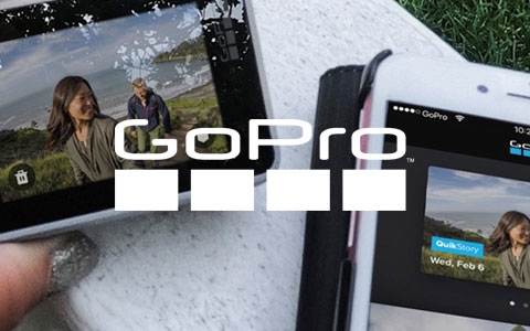 GoPro camera in female's hand and iPhone next to it.