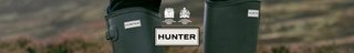 Green Hunter wellies in the outdoors with the Hunter logo in the middle.