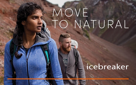 Man and women walking through rocky terrain wearing Icebreaker clothing