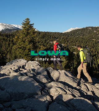 Man lying on a ledge wearing Lowa gear.