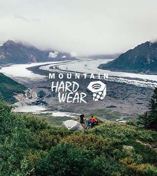 Two people camping in mountains using Mountain Hardwear tents and Mountain Hardwear sleeping bags, wearing Mountain Hardwear clothing