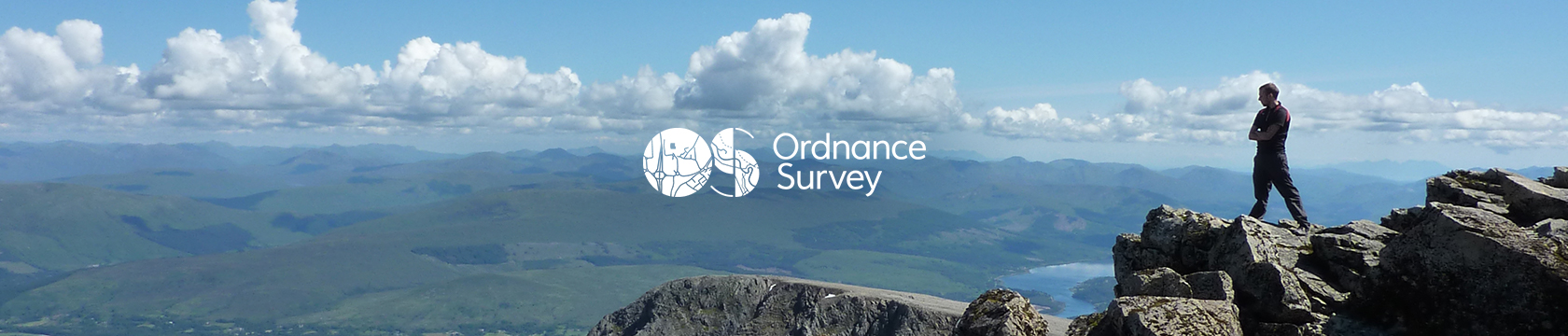 Man on rocks enjoying the view down, wearing Ordnance Survey gear.