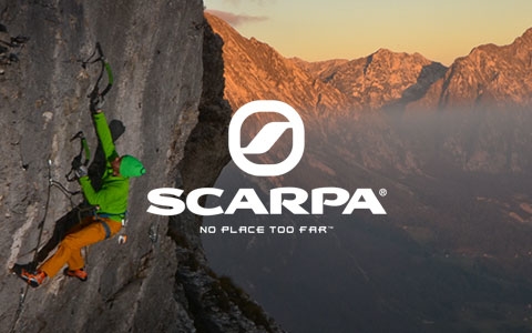 Man is climbing up a rock, wearing Scarpa climbing shoes