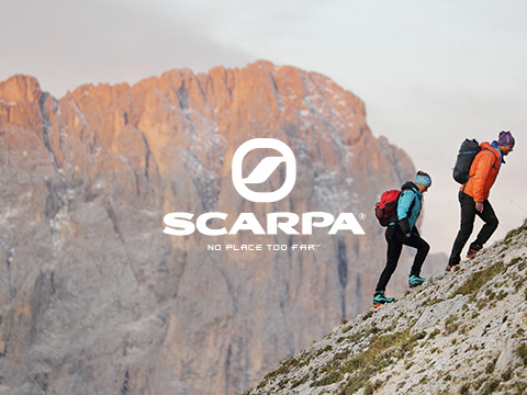 Man and a woman walking up a mountain with rucksacks, wearing Scarpa walking boots