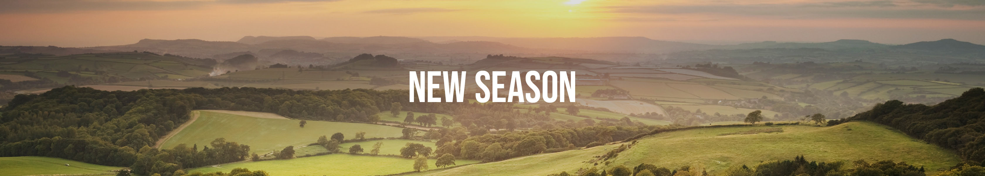 Shop Cotswold Outdoor New Season. New season text over a beautiful countryside view