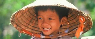 Smiling Vietnamese child wearing traditional hat