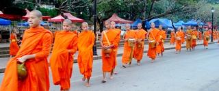 Line of young people from SE Asia walking in orange clothing