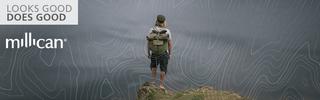 man stands on rock overlooking a valley