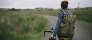 Woman next to bike while wearing her Millican Maverick Backpack