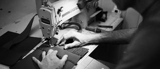 Man stitches together a sustainable millican bag