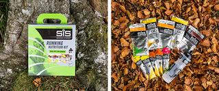 A package of SIS Running Nutrition leaning against a tree trunk, and then the contents fanned out on some leaves
