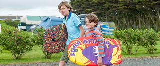 Two boys carrying surf boards