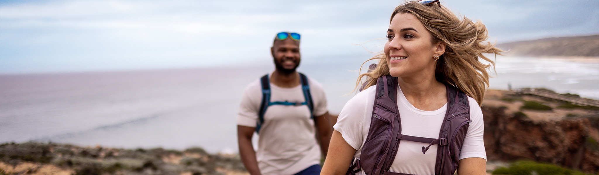 Man and woman hiking by the sea