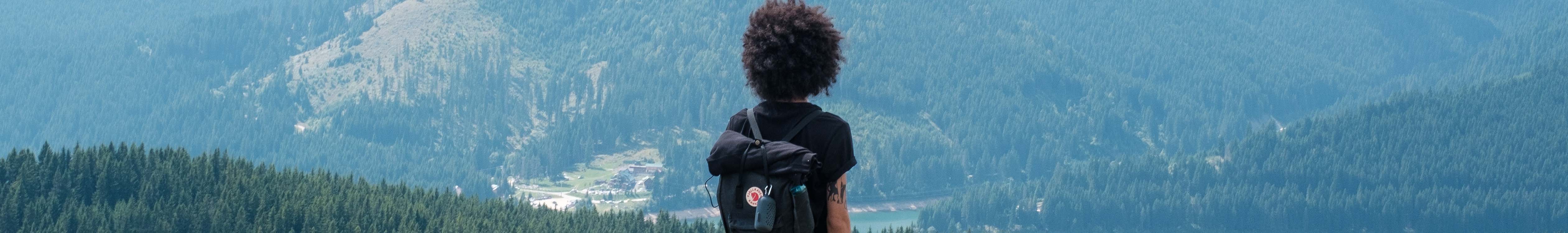 A person hiking wearing a Fjallraven Kanken backpack
