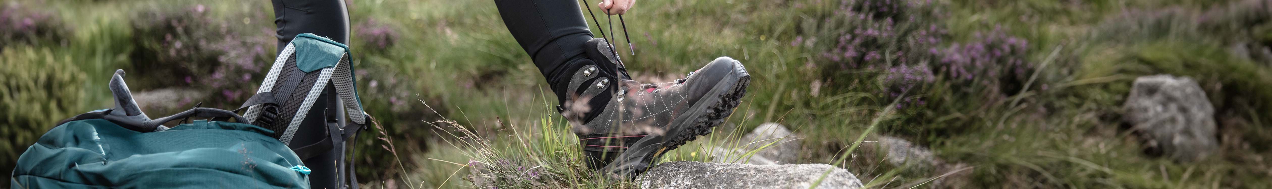 A boot being tied on a rock