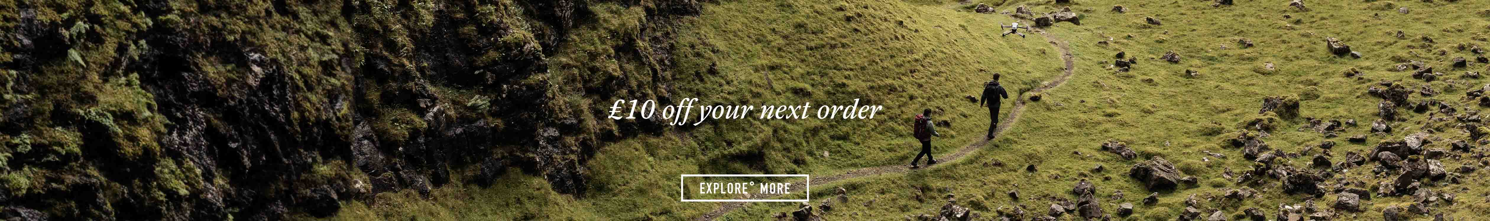 £10 off your next order - Two people are walking on a path next to some hills