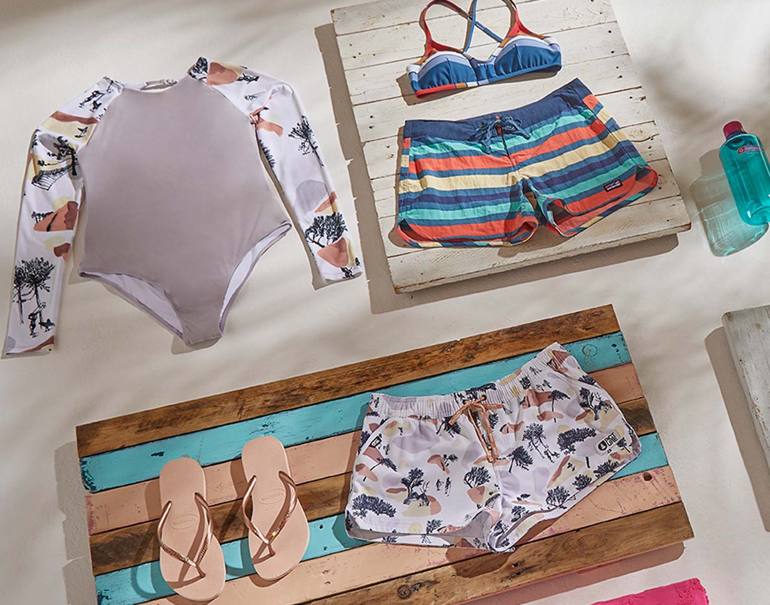 Women's beach clothing, flip flops, and a water bottle