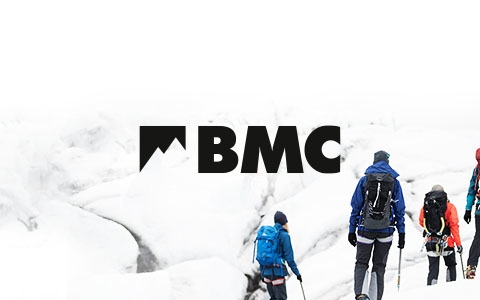 BMC logo in black on a white snowy background with 4 people to the right of the screen wearing ski gear