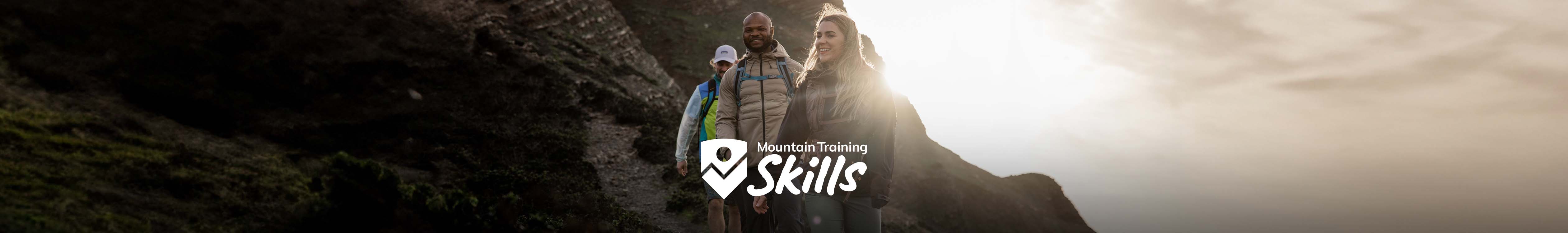 man and woman walking with mountain training logo