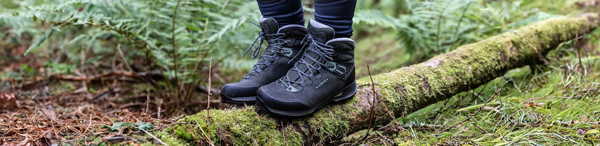 Shop Walking boots. A person stood on a log in walking boots 