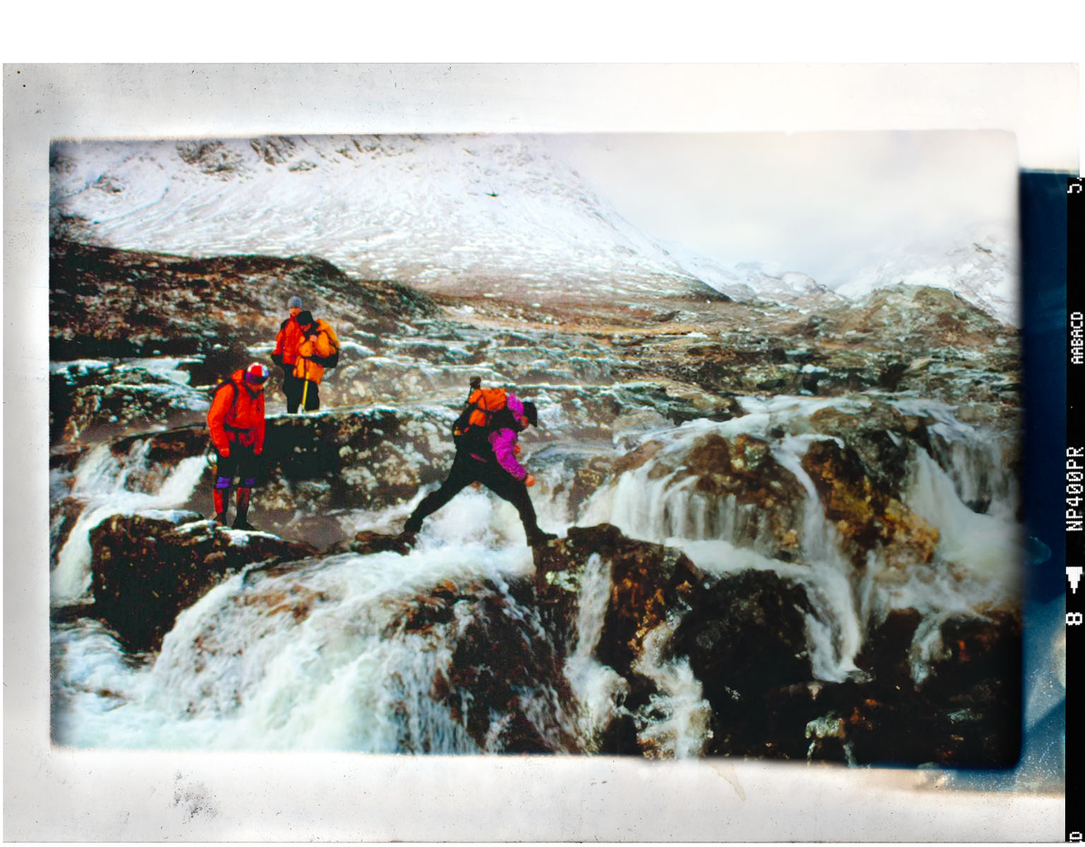 three people walking over rocky path