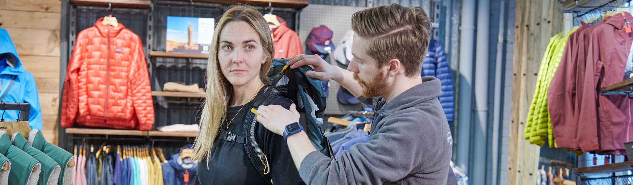 A woman getting a rucksack fitted by an expert