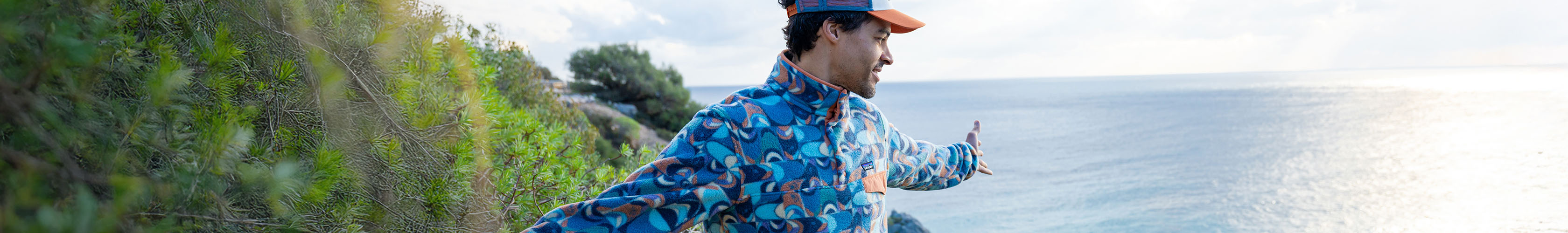A man wearing a fleece by the coast 