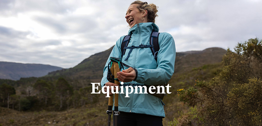 Woman walking in the mountains with hiking poles and backpack