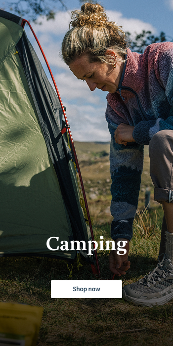 woman pitching a tent in the nature