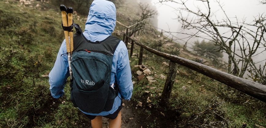 Women walking in the mountains with hiking poles and backpack