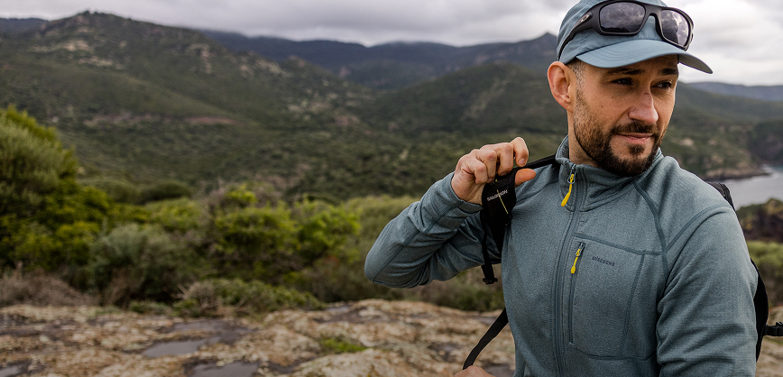 Men wearing a fleece, pack, cap and sunglasses in the mountain from the new season collection