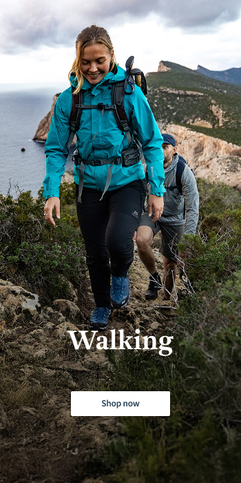 Woman and man walking in the costatal path with views to a clif and sea