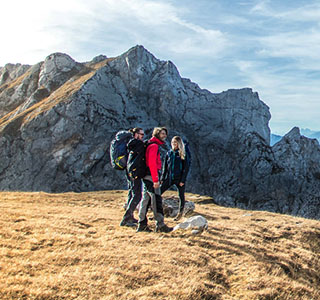 People standing on a mountain wearing and carrying DofE recommended kit.