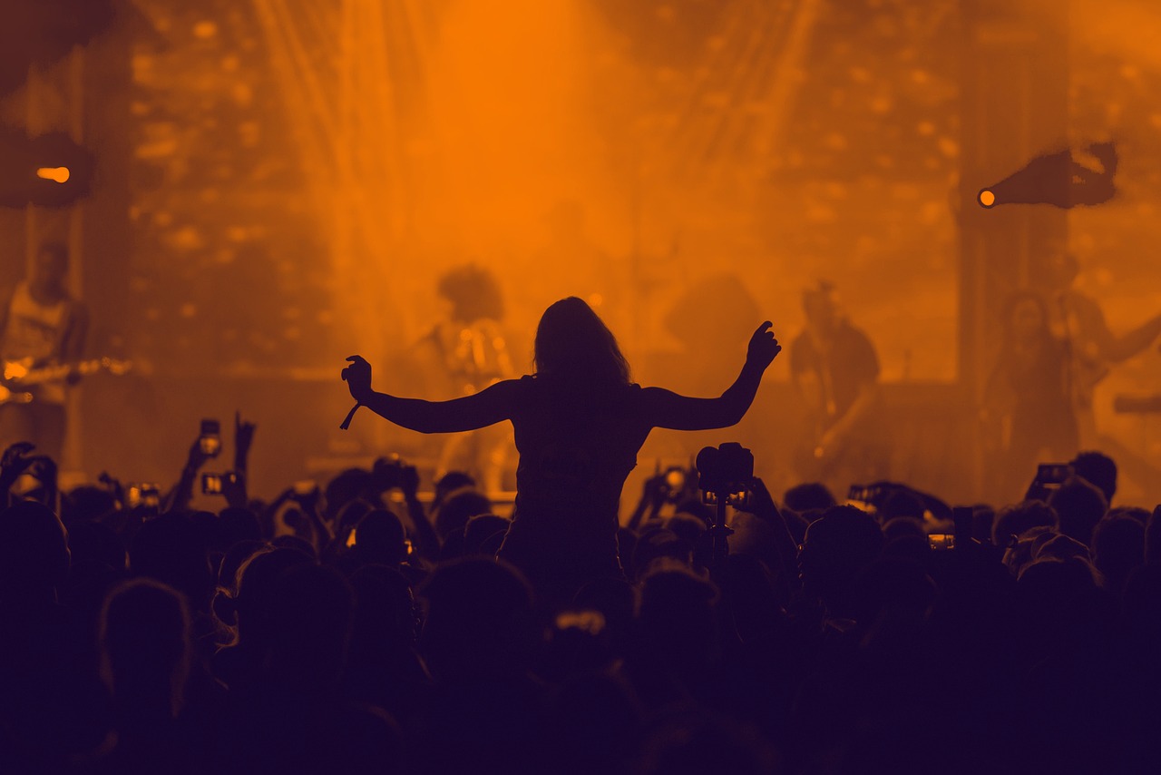 A woman on someone's shoulders in the crowd at Latitude Festival 