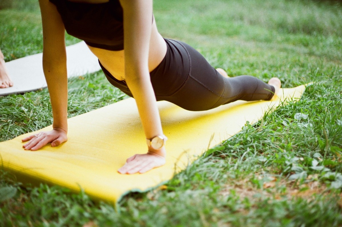 A woman in an upward dog yoga position outside 