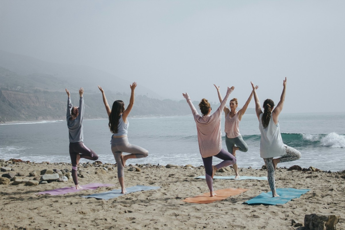 A group of people doing beach yoga