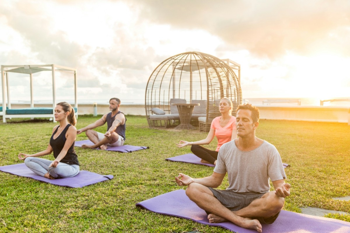 A group of people doing yoga outside