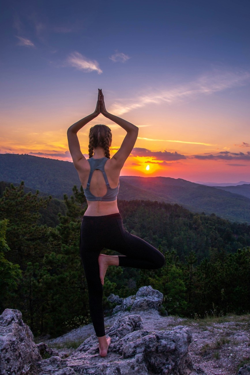 A woman doing a yoga pose outside 