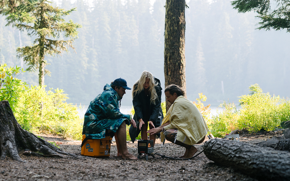Three friends eating marshmallows by the fire