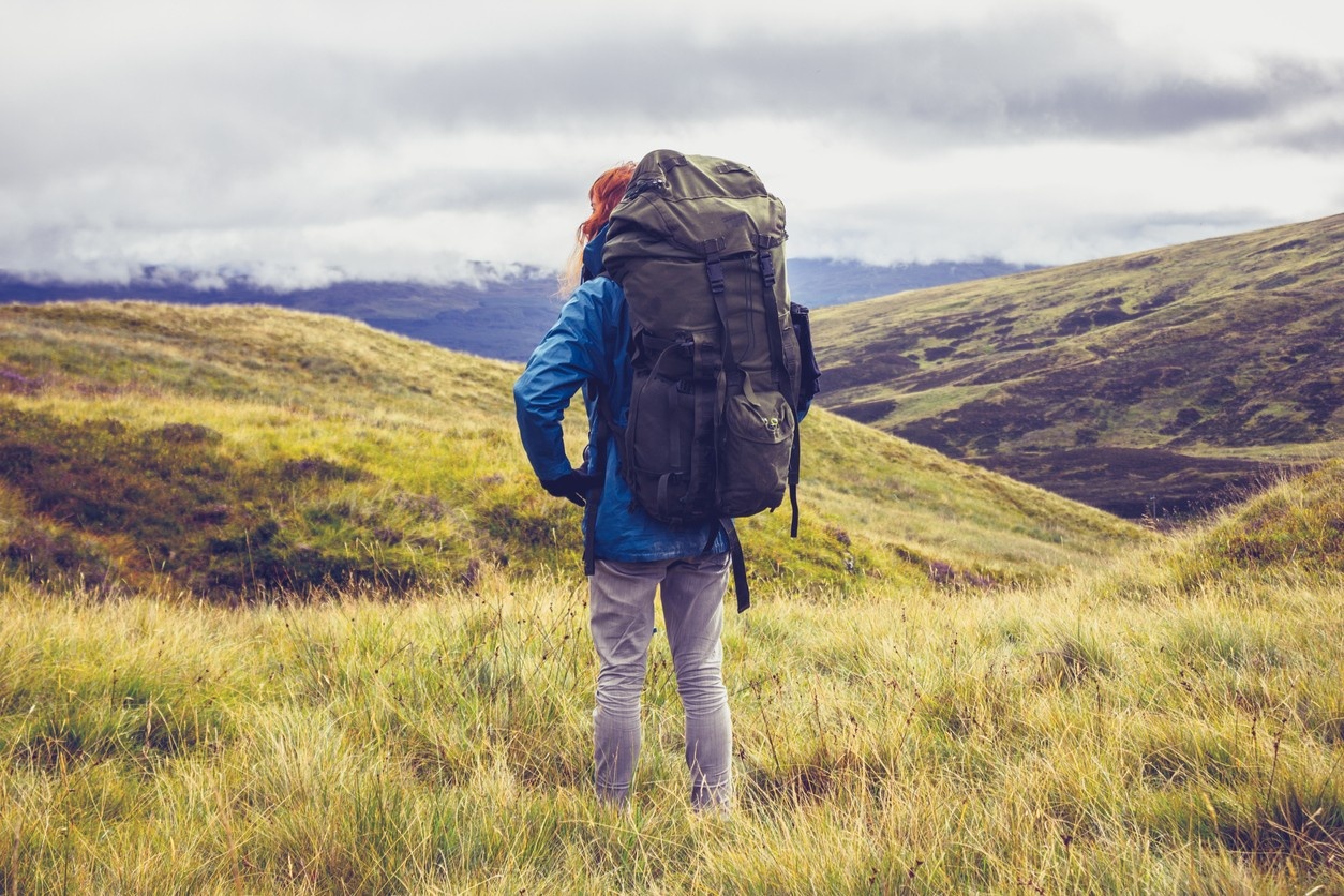 Woman carrying her tent and essentials in her rucksack