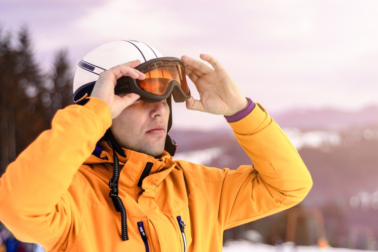 A man putting on his ski goggles 